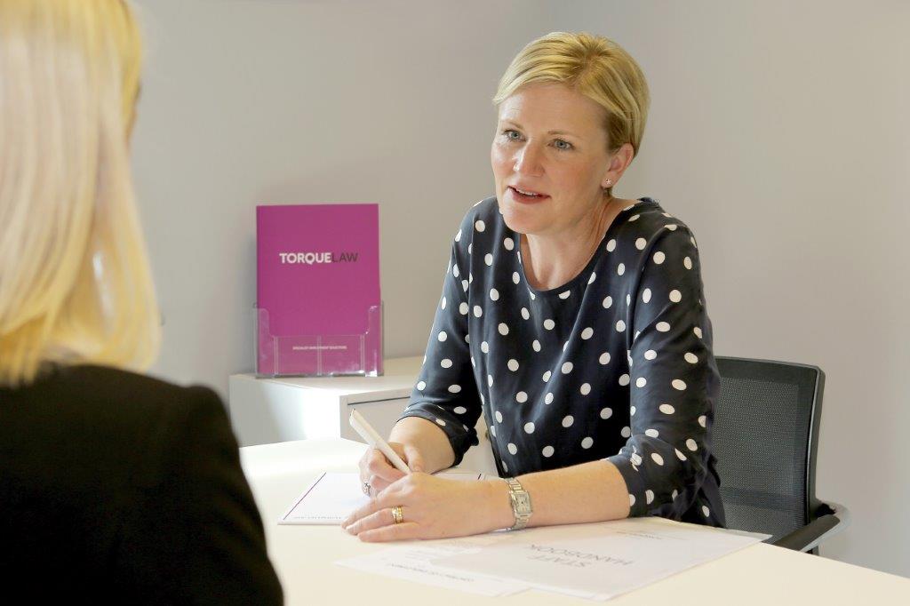 Tiggy consulting behind a desk